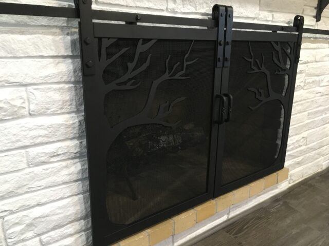 Fireplace doors on a rolling track- custom designed with trees